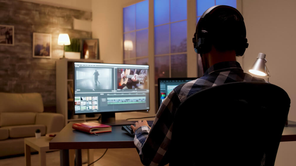 back-view-content-creator-working-home-office-during-night-time-video-editor
